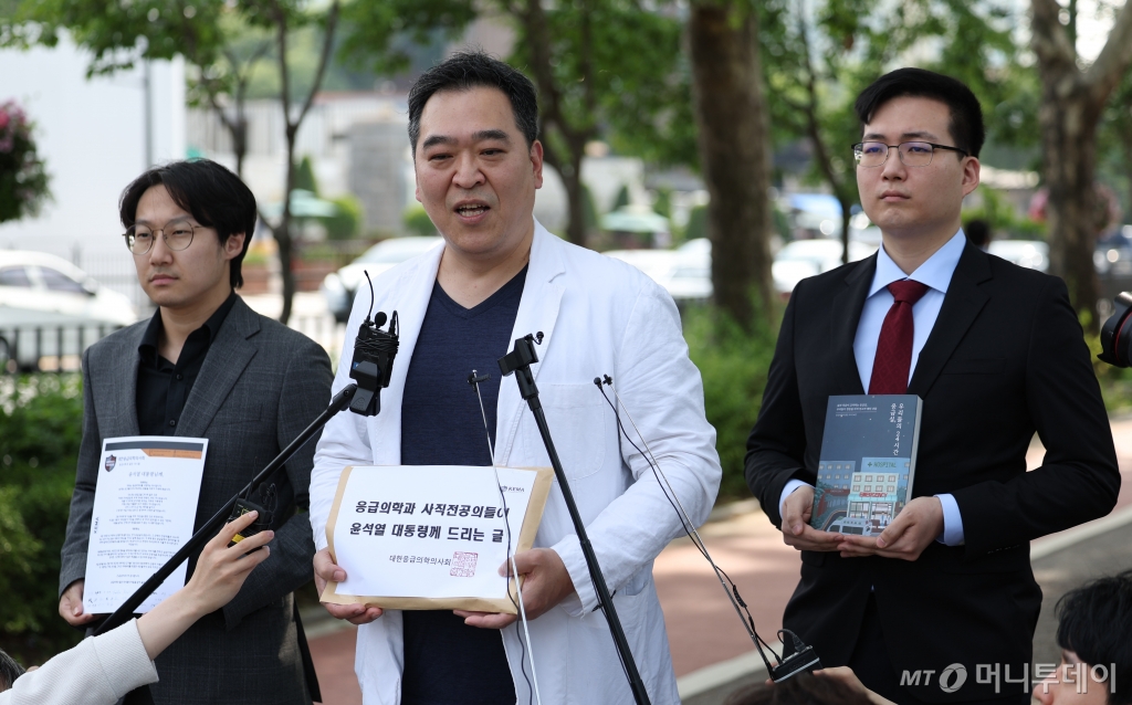 [서울=뉴시스] 김선웅 기자 = 대한응급의학의사회 이형민 회장과 사직 전공의들이 22일 서울 용산 대통령실 앞에서 '대통령께 드리는 글'과 응급의학 관련 책을 전달하기 전 입장을 말하고 있다. 2024.05.22. mangusta@newsis.com /사진=김선웅