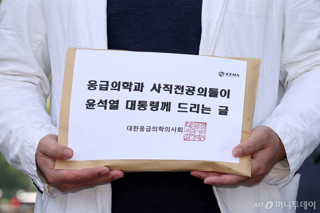 (서울=뉴스1) 장수영 기자 = 이형민 대한응급의학의사회 회장이 22일 오후 서울 용산구 대통령실 앞에서 윤 대통령에게 전달할 '응급의학과 사직전공의들이 윤석열 대통령께 드리는 글'을 들어보이고 있다. 2024.5.22/뉴스1  Copyright © 뉴스1. All rights reserved. 무단 전재 및 재배포,  AI학습 이용 금지. /사진=(서울=뉴스1) 장수영 기자