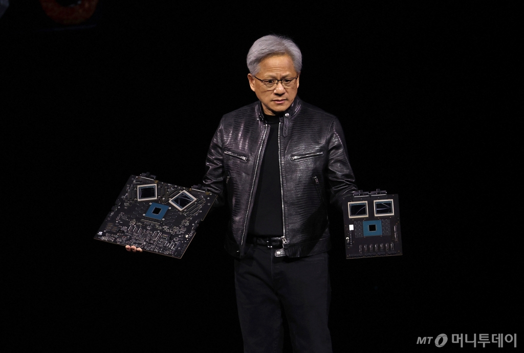 (새너제이 AFP=뉴스1) 김성식 기자 = 젠슨 황 엔비디아 최고경영자(CEO)가 18일(현지시간) 미국 캘리포니아 새너제이에서 진행된 엔비디아 주최 연례 개발자 회의 'GTC 2024'에서 생성형 인공지능(AI) 모델을 겨냥한 차세대 그래픽처리장치(GPU) 블랙웰(제품명 B200)을 공개하고 있다. 2024.3.18.  ⓒ AFP=뉴스1  Copyright © 뉴스1. All rights reserved. 무단 전재 및 재배포,  AI학습 이용 금지. /사진=(새너제이 AFP=뉴스1) 김성식 기자