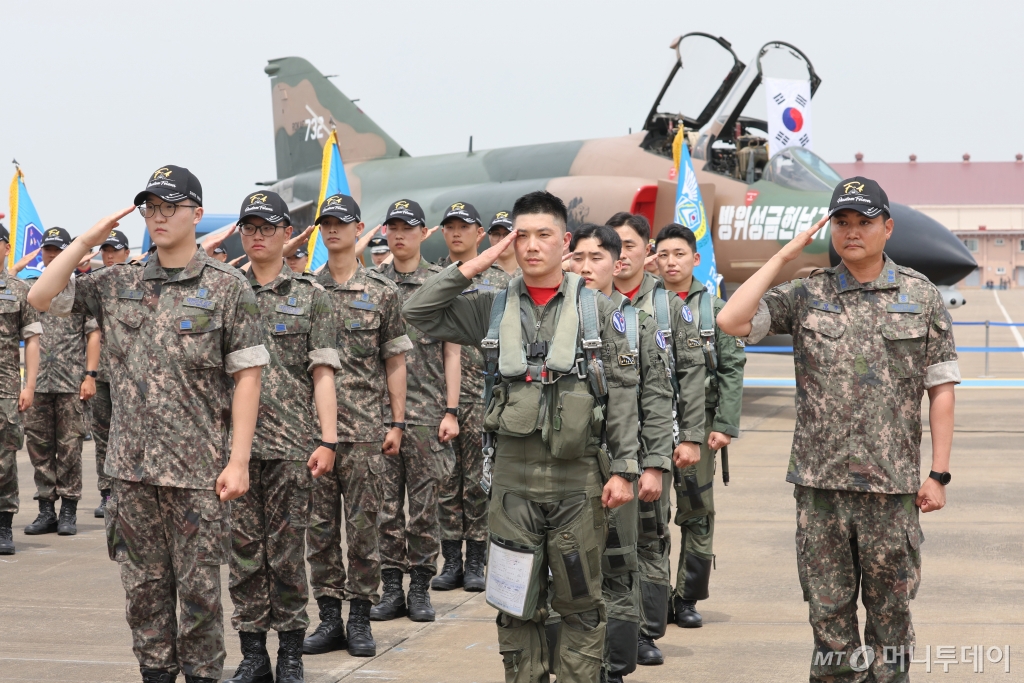 7일 경기도 수원시 공군10전투비행단에서 열린 F-4 팬텀(Phantom) 퇴역식에서 장병들이 퇴역하는 F-4 팬텀 전투기를 향해 거수경례를 하고 있다.   이날 퇴역한 F-4E는 F-4D의 공대공·공대지 능력을 강화한 개량형으로, 1967년 미국 맥도널 더글러스사(社)(1997년 보잉에 합병)가 전천후 전폭기(전투기+폭격기)로 개발한 것이다. / 사진=뉴스1
