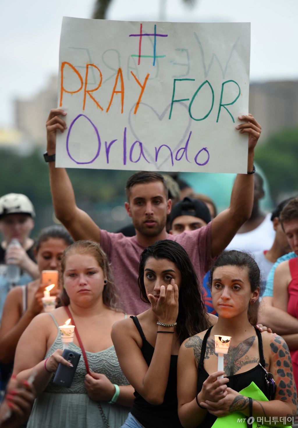 미국 플로리다주 올랜도 공원에서 2021년 6월12일(현지시간) 한 남성이 게이클럽 총기난사 사건 희생자 추모 행사에 참석해 "올랜도를 위해 기도하라"고 씌여진 종이를 들어보이고 있다. /사진=뉴시스