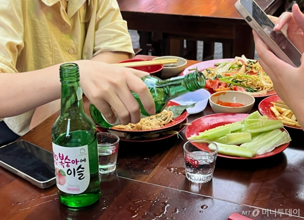 베트남 하노이 따이헨의 맥주 골목에서 현지인이 하이트진로의 과일소주를 마시는 모습./사진=유예림 기자