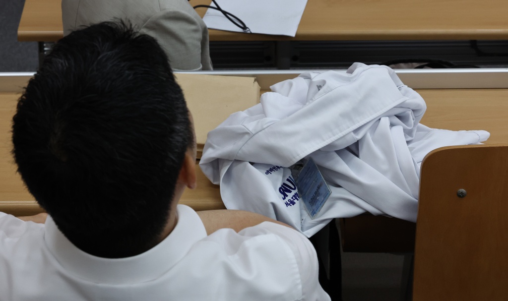 17일 서울시 종로구 서울대학교 의과대학 융합관 양윤선홀에서 열린 서울대학교 의과대학-서울대학교병원 교수협의회 비상대책위원회 주최 심포지엄에서 교수가 의사 가운을 벗어두고 안덕선 의료정책연구원장의 강연을 듣고 있다.  비대위는 교수들에게 불가피한 진료 이외에는 총회 및 세미나에 참석하는 것을 원칙으로 한다고 공지했다. /사진=뉴시스