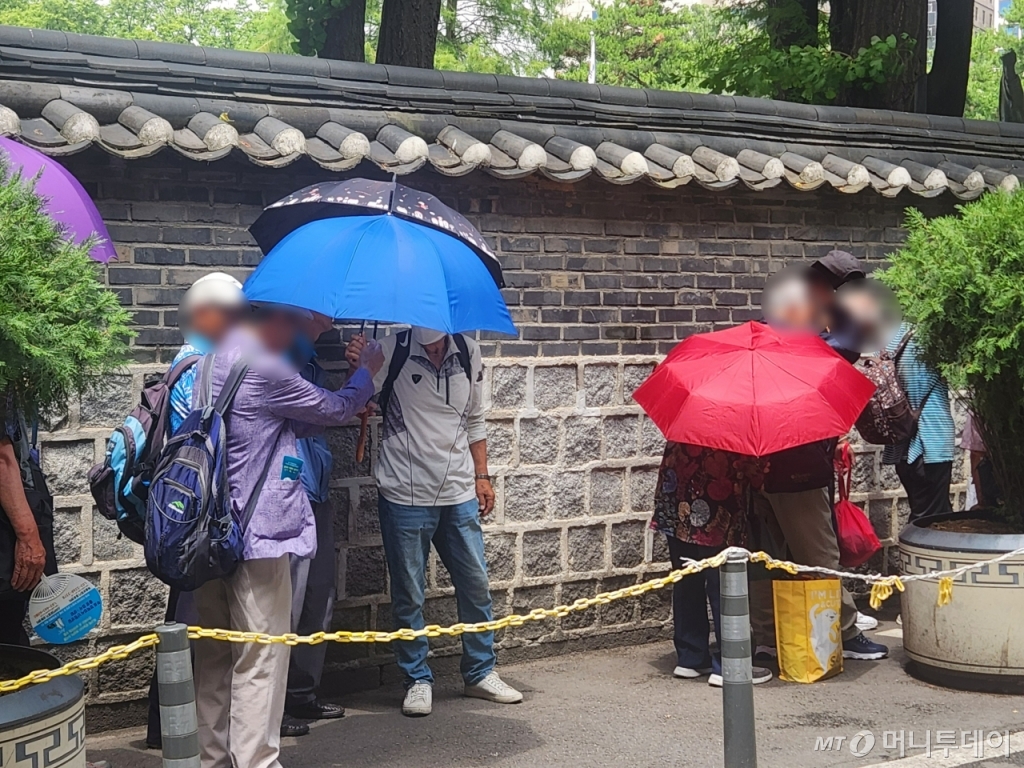 올해 6월 이른 무더위가 이어지며 독거노인들의 여름 나기도 빠르게 시작됐다. 24일 서울 종로구 탑골공원 원각사 무료급식소 앞 노인들이 볕을 피하기 위해 우산을 쓴 채 배식을 기다리고 있다./사진=최지은 기자