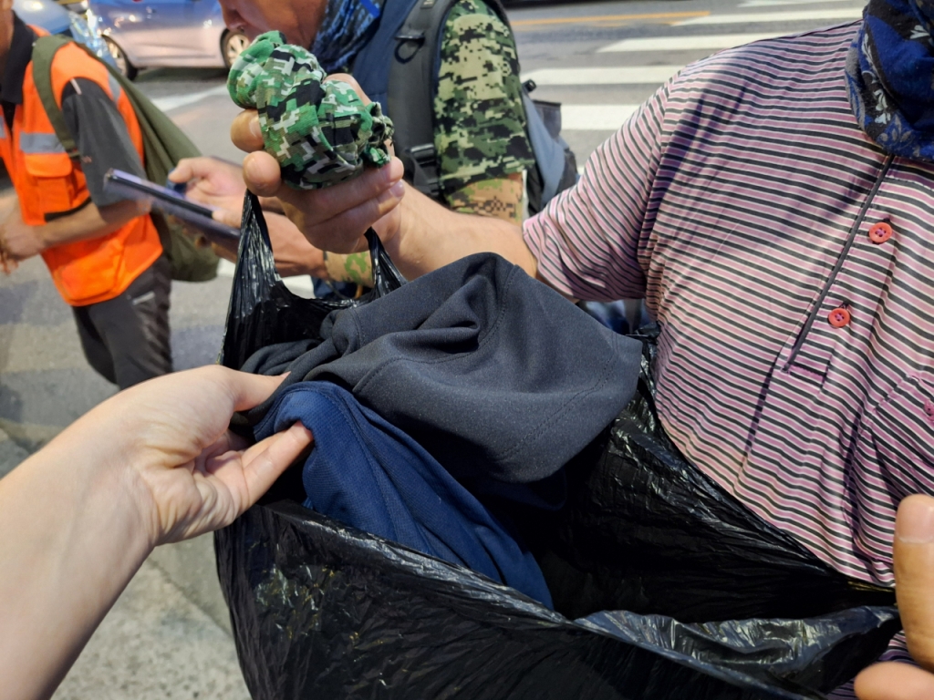27일 오전 5시쯤 서울 구로구 남구로역 인근 삼거리 인력시장. 한 남성이 당일 입을 작업복을 보여주고 있다. /사진=김지은 기자