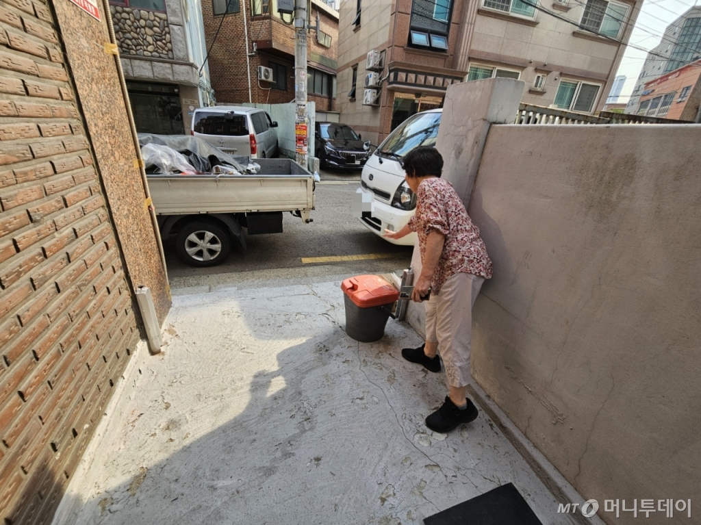 지난 27일 서울 관악구 신림동의 한 주택가에서 박씨가 물막이판의 높이가 너무 낮다고 말하고 있다. 박씨는 2022년 여름 수해 당시 현재 설치된 물막이판 높이보다 훨씬 높은 곳까지 물이 찾다며 손으로 높이를 가늠하고 있다. /사진=정세진 기자 