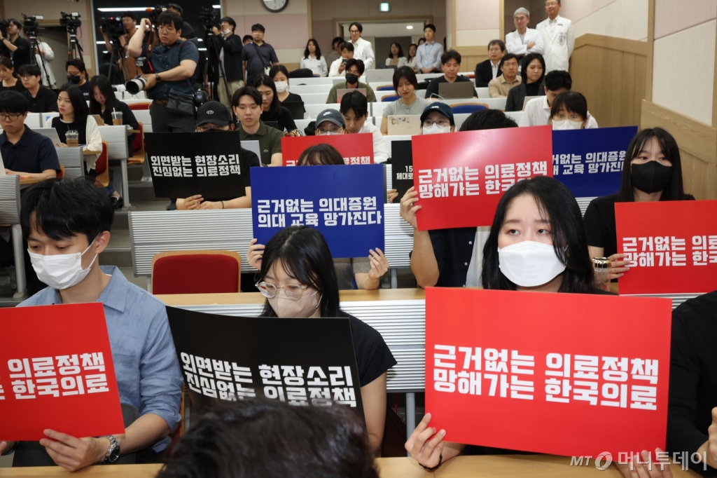 [서울=뉴시스] 김금보 기자 = 서울대병원 교수들이 전공의 사태 해결 등을 요구하며 무기한 휴진에 들어간 17일 오전 서울 종로구 서울대학교 의과대학 융합관 양윤선홀에서 열린 서울의대-서울대병원 비대위 집회에서 의료진들이 피켓을 들고 있다. 2024.06.17. kgb@newsis.com /사진=김금보