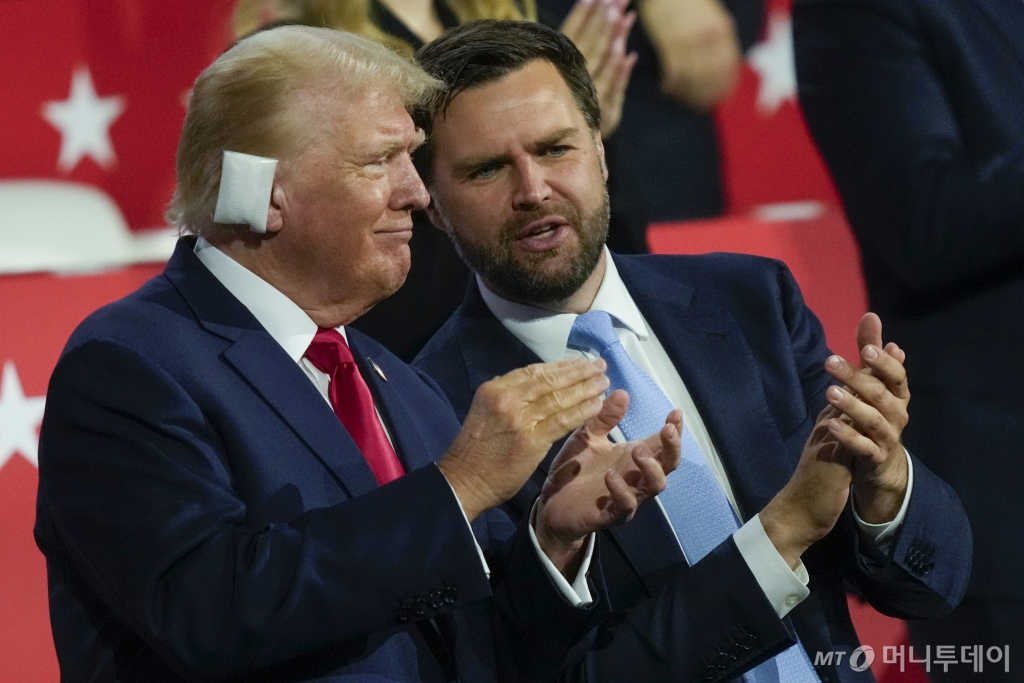 [밀워키=AP/뉴시스] 미국 공화당 대선 후보 도널드 트럼프(왼쪽) 전 대통령이 귀에 거즈를 붙인 채 15일(현지시각) 미 위스콘신주 밀워키의 파이서브포럼에서 개막한 공화당 전당대회(RNC)에 참석해 JD 밴스 부통령 후보와 얘기하고 있다. 2024.07.16. /사진=민경찬