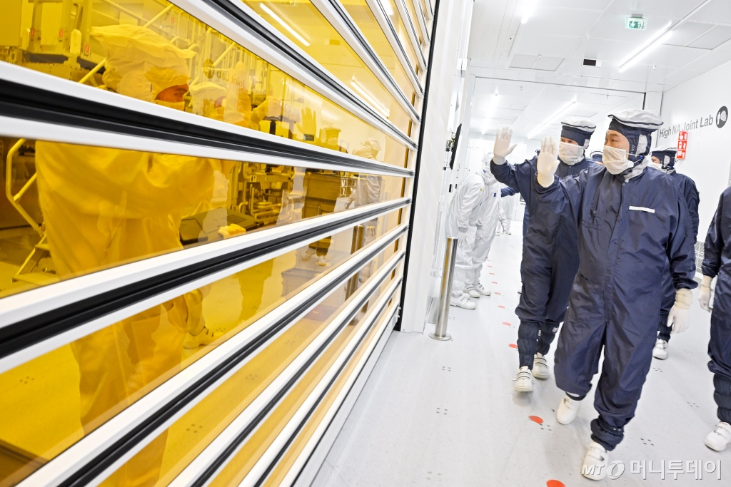 [벨트호벤=뉴시스] 조수정 기자 = 네덜란드를 국빈 방문한 윤석열(오른쪽 앞) 대통령이 빌럼 알렉산더르 네덜란드 국왕과 함께 12일(현지시간) 벨트호벤 반도체장비 생산기업인 ASML 본사에서 클린룸을 시찰하며 직원들에게 손을 흔들고 있다. (공동취재) 2023.12.13. chocrystal@newsis.com /사진=