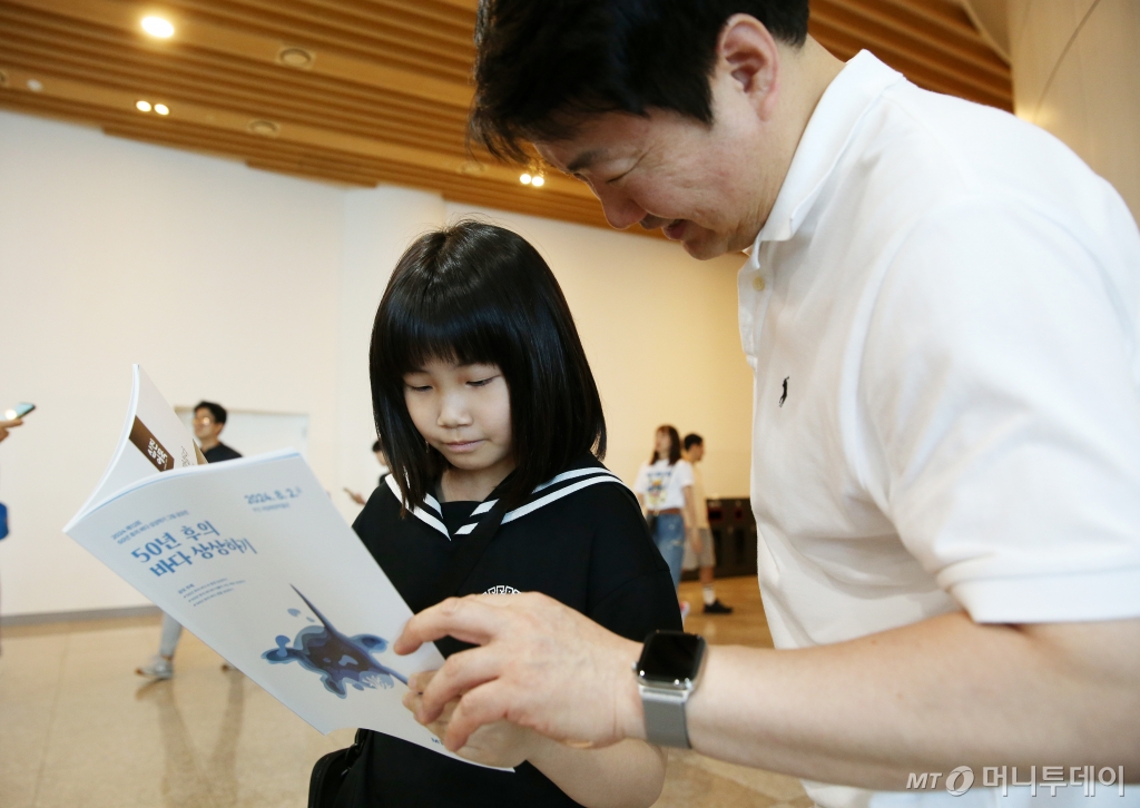 50년후의 바다상상하기 그림공모전 시상식 수상작 도록을 보고 있는 학생과 학부모 /사진=김휘선 기자 hwijpg@