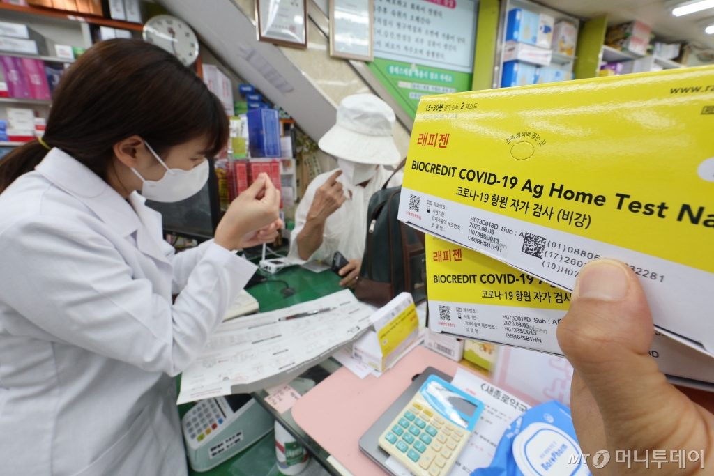 (서울=뉴스1) 신웅수 기자 = 신종 코로나바이러스 감염증(코로나19)이 재유행하고 있는 18일 서울 종로구 새종로약국에서 약사가 코로나19 자가 키트를 구매하는 고객에게 사용법을 알려주고 있다.  코로나19 환자가 6주 만에 약 22배로 폭증하면서 치료제와 진단키트 품귀 현상이 전국 곳곳에서 발생하고 있다.  생산공장에서는 재고가 바닥나 공장을 풀가동하고 있는 상황이며 진단키트 제조업체들은 이번주 공급 물량도 납품 예약이 완료될 정도로 제품 조달에 어려움을 겪고 있다. 2024.8.18/뉴스1  Copyright © 뉴스 /사진=(서울=뉴스1) 신웅수 기자