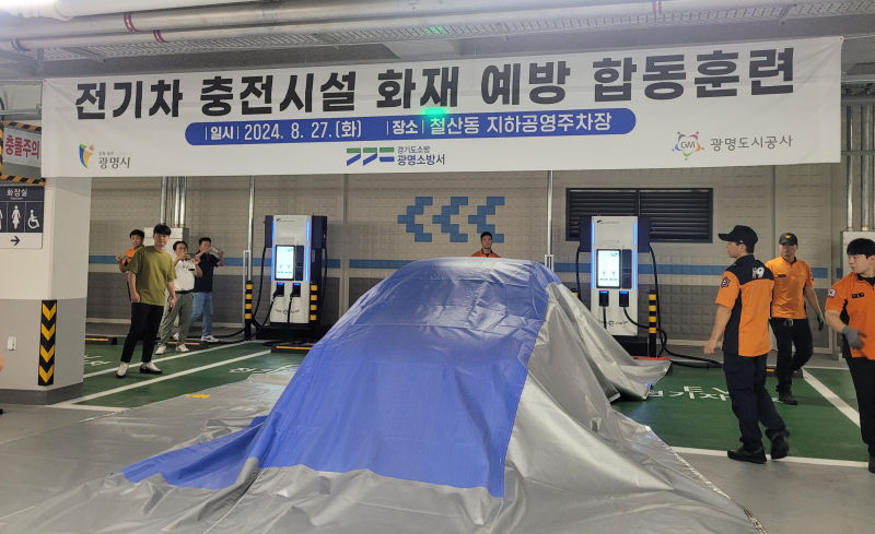 광명시가 지난달 27일 철산동 지하공영주차장에서 광명소방서와 '전기차 충전시설 화재 예방 합동훈련'을 실시, 질식소화포 사용법을 시연하는 모습./사진제공=광명시