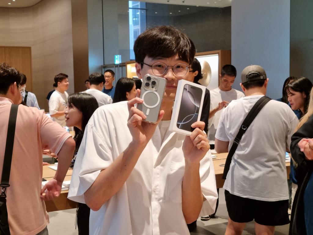  한국 1호 아이폰16 시리즈 수령자 IT블로그 '미유테크시티'의 김민재(28세)씨가 20일 서울 중구 애플 명동에서 구매한 아이폰16 프로 화이트 티타늄 제품을 들어보이고 있다.  /사진=배한님 기자 