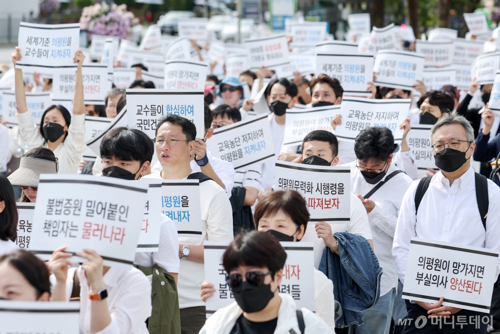 (서울=뉴스1) 민경석 기자 = 전국 의과대학 교수들과 학생들이 3일 오후 서울 용산구 대통령실 앞에서 열린 '의학교육평가원 무력화 저지를 위한 전국의과대학 교수 결의대회'에서 구호를 외치고 있다.  이날 참가자들은 의대 증원으로 의과대학 교육 여건이 나빠져 의평원의 인증 평가에서 불인증을 받더라도 처분을 1년 이상 유예하는 내용을 담은 정부의 '고등교육기관의 평가·인증 등에 관한 규정' 개정안 입법예고를 즉각 철회하라고 촉구 했다. 2024.10.3/뉴스1  Copyright © 뉴스1. All rights reserve /사진=(서울=뉴스1) 민경석 기자