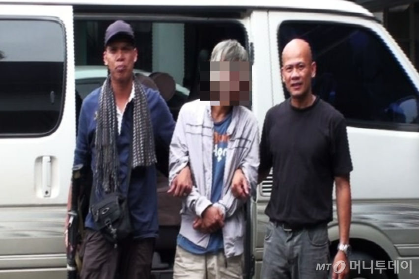 2012년 대한민국 경찰과 필리핀 납치수사단이 공조해 필리핀 현지에서 검거한 김종석(가운데)의 모습. 김종석은 2007년 경기 안양시 한 환전소에서 여직원을 살해한 뒤 필리핀으로 도주해 현지에서 연쇄 납치 범행을 벌였다. /사진=머니투데이DB, 경찰청 제공