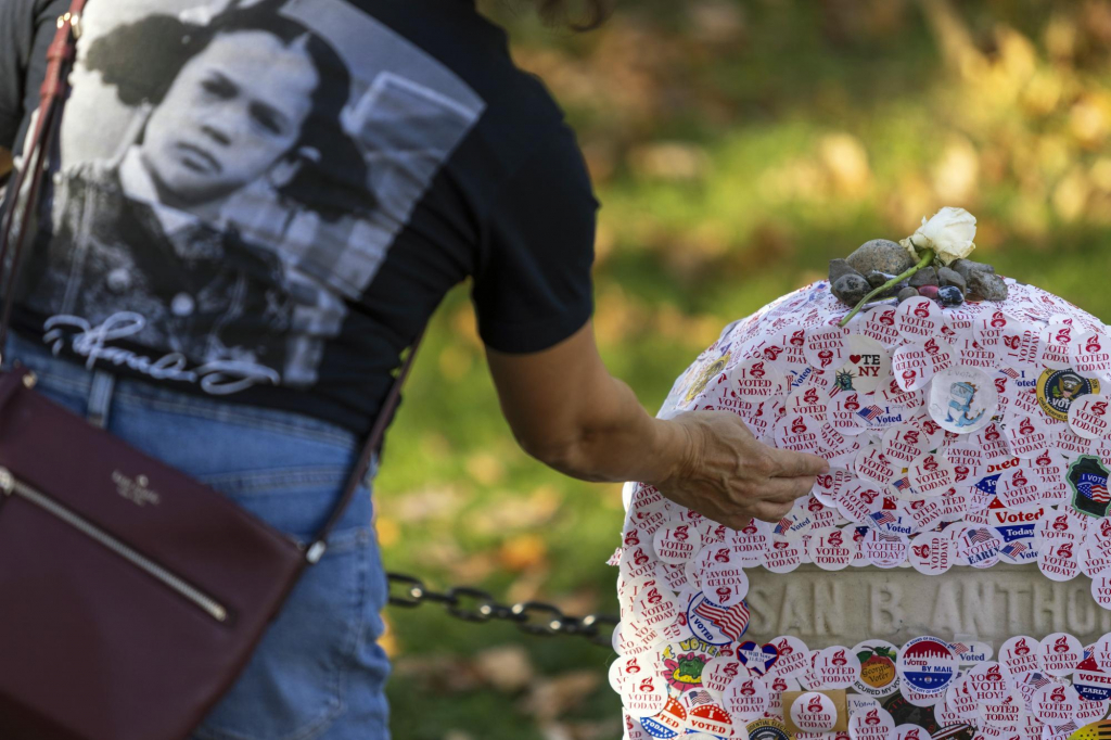  5일(현지시각) 미 뉴욕주 로체스터에 있는 마운트 호플 묘지에서 카멀라 해리스 부통령의 어린 시절 모습이 있는 티셔츠를 입은 한 유권자가 여성 참정권 운동가인 수잔 B. 앤서니의 묘비에 '투표 완료' 스티커를 붙이고 있다. '우리 모두의 어머니'로 불리는 앤서니는 1872년 11월 5일 여성으로는 처음으로 미 대통령 선거 투표를 강행했으며 이로 인해 100달러 벌금형을 받기도 했다. /AP=뉴시스