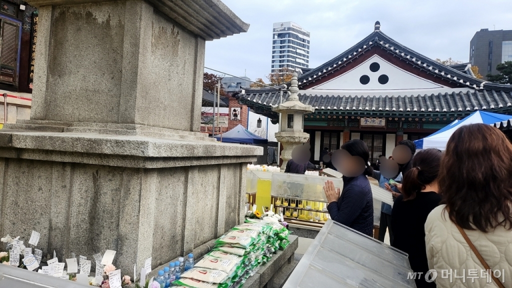 14일 오전 9시 20분쯤 서울 강남구 봉은사 대웅전 앞. 한 중년 여성이 손을 모아 기도하고 있다. 탑 앞에는 수능 응원 문구가 적힌 공양미, 촛불, 작은 화분 등이 놓여있다./ 사진=송정현 기자