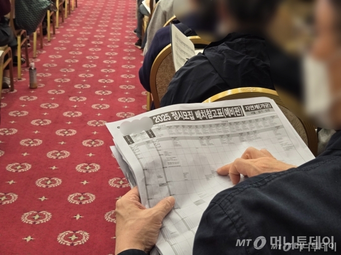 수능 다음날인 15일 오후 3시. 2025학년도 대학수학능력시험 이후 사립학원에서 개최한 대학 입시설명회에서 한 남성이 정시모집 배치 참고표를 펼치고 손가락으로 짚으며 읽고 있다 /사진=이혜수 기자