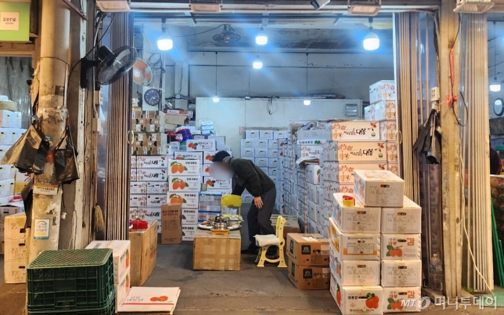 18일 서울 동대문구 청량리청과물시장에서 한 상인이 귀마개를 낀 채 일을하고 있다./사진=송정현 기자