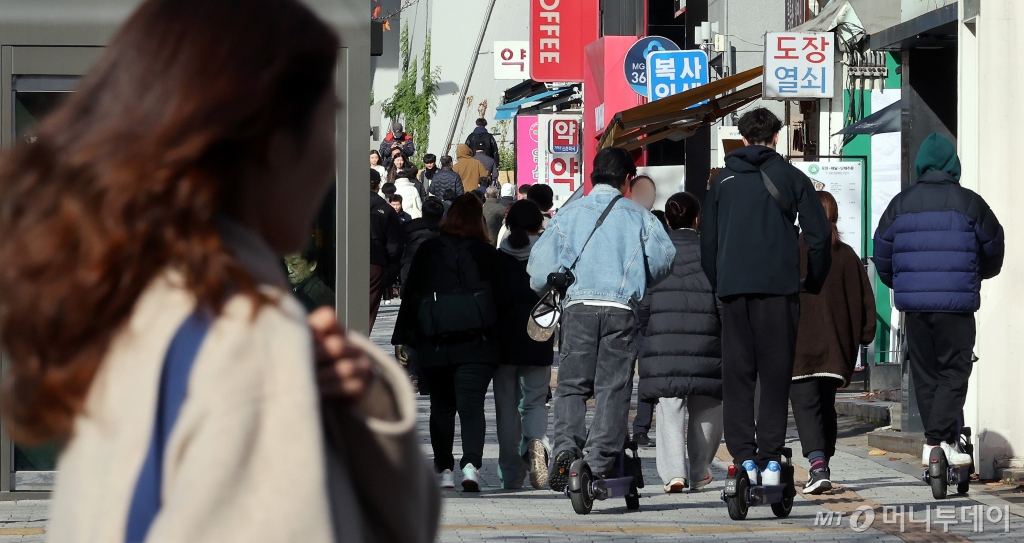 (서울=뉴스1) 이동해 기자 = 19일 서울 시내에서 외국인 관광객들이 전동킥보드를 타고 있다.  19일 업계에 따르면 경찰청은 늦어도 내년 1월까지 유관기관 단체와 협의해 전동킥보드 등 개인형 이동장치(PM) 전용 운전면허 신설과 관련한 합리적 안을 도출할 계획이라고 전했다. 현재 도로교통법상 공유 전동킥보드는 제2종 원동기장치자전거 면허 또는 그 이상(제2종 소형·보통면허, 제1종 보통면허 등)의 운전면허 소지자만 이용할 수 있다. 면허 취득 방식으로는 세 가지가 거론된다. 학과시험(필기시험)만 치르거나, 학과와 기능시험(실습시험)을 함께 치르거나, 온라인 교육만 이수하는 방안 등이 있다. 2024.11.19/뉴스1  Copyright © 뉴스1. All rights reserved. 무단 전재 및 재배포,  AI학습 이용 금지. /사진=(서울=뉴스1) 이동해 기자