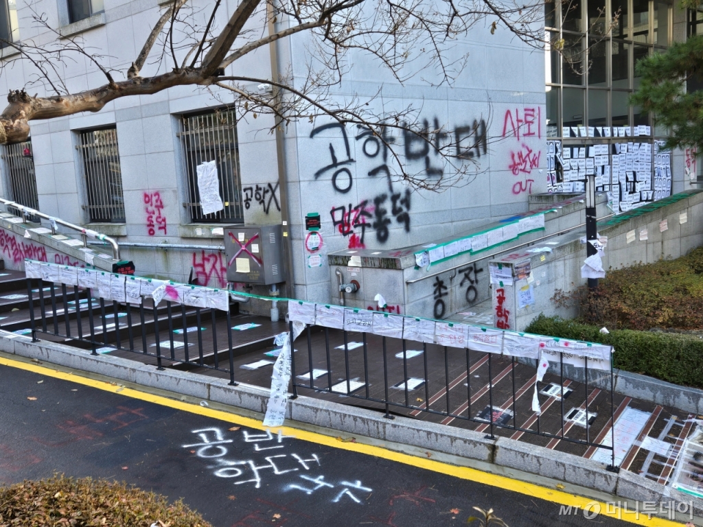 26일 동덕여대 교정 모습. 전단은 비에 젖어 찢어져 흔들리고 있고 건물 외벽과 콘크리트 바닥엔 '공학반대', '민주동덕' 등이 래커 스프레이로 쓰여있다/사진=이혜수 기자