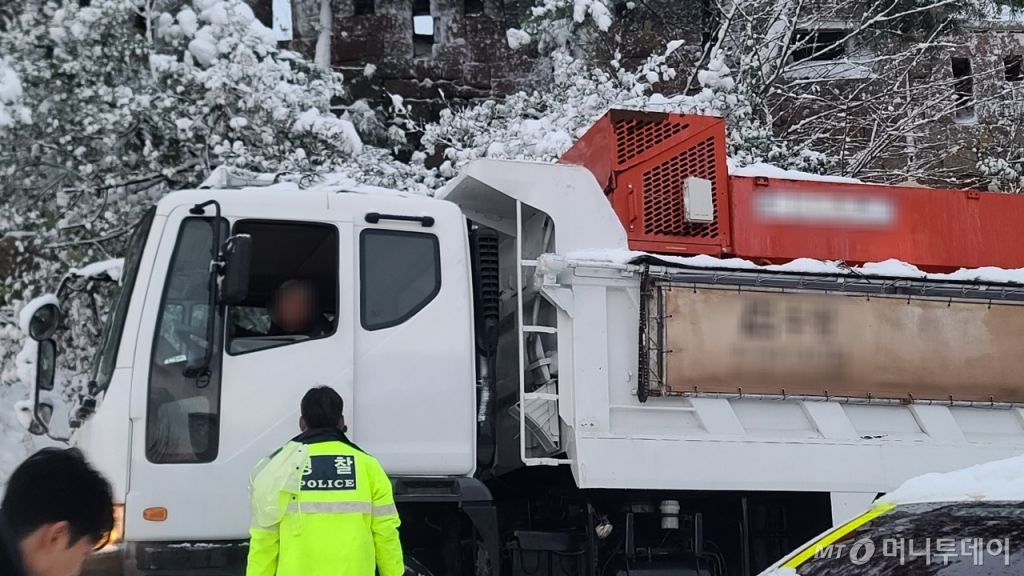순찰차를 뒤로 차량 3대가 따라오자 차량에서 내린 경찰관들이 도로를 우회해서 가라고 안내했다. 경찰관의 설명을 들은 시민들은 별다른 내색 없이 차량을 돌렸다./사진=이찬종 기자 