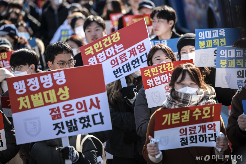[서울=뉴시스] 정병혁 기자 = 8일 서울 종로구 대학로에서 열린 서울대병원 전공의협의회 비상대책위원회 ‘젊은 의사 의료계엄 규탄 집회’에서 사직 전공의를 비롯한 젊은 의사들이 피켓을 들고 있다. 2024.12.08. jhope@newsis.com /사진=정병혁