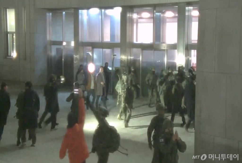 (서울=뉴스1) = 국회사무처가 계엄군의 국회 본관 진입 과정이 담긴 CCTV를 4일 공개했다.   김민기 국회사무총장은 국방부가 헬기로 24차례에 걸쳐 무장한 계엄군 230여 명을 국회 경내로 진입시켰다며 0시 40분에는 계엄군 50여 명을 추가로 국회 외곽 담장을 넘어 진입시켰다고 전했다.  사진은 국회 본관 진입을 시도하는 계엄군 모습. (국회사무처 제공) 2024.12.4/뉴스1  Copyright © 뉴스1. All rights reserved. 무단 전재 및 재배포,  AI학습 이용 금지. /사진=(서울=뉴스1)