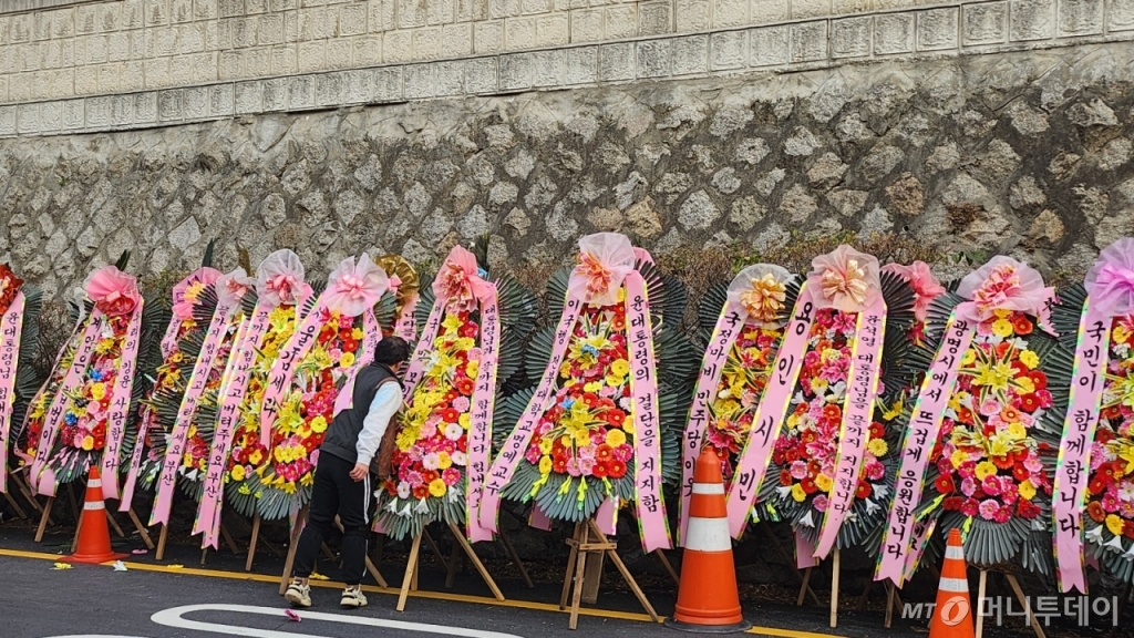 11일 오후 3시40분 용산 대통령실 입구 쪽 오르막길에 윤대통령을 지지하는 문구가 달린 근조화환들이 놓여있다. "대통령을 지켜 나라를 지키자" "지금 대한민국 대통령은 윤석열" 등의 문구가 놓여있다. /사진=송정현 기자