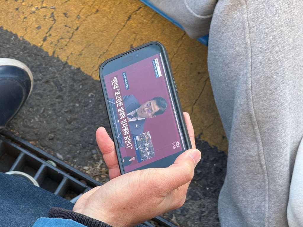 14일 오후 4시10분 대형 스크린이 멀리 있어 유튜브 생중계로 실시간 국회 상황을 보고 있는 시민들 모습. /사진=김선아 기자