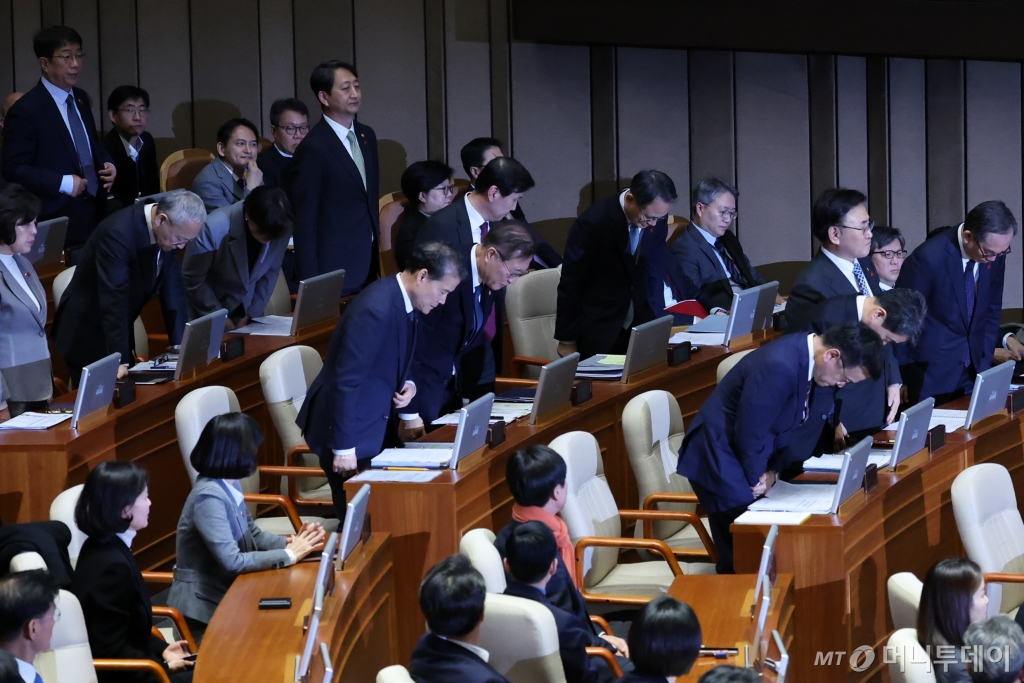 [서울=뉴시스] 조성우 기자 = 11일 오후 서울 여의도 국회에서 열린 제419회국회(임시회) 제1차 본회의 윤석열 대통령 위헌적 비상계엄 선포 내란행위 관련 긴급현안질문에 출석한 최상목 경제부총리 겸 기획재정부 장관과 이주호 사회부총리 겸 교육부 장관 등 국무위원들이 서영교 더불어민주당 의원의 계엄 사태와 관련해 사과를 요구하자 고개를 숙이고 있다. 2024.12.11. xconfind@newsis.com /사진=조성우