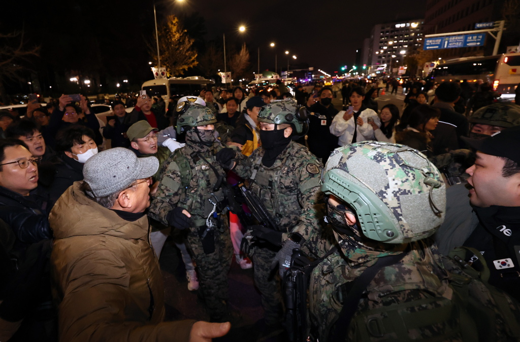  윤석열 대통령이 비상계엄령을 전격 선포한 가운데 4일 새벽 서울 여의도 국회 앞에서 시민들이 경내로 진입하려는 계엄군을 붙잡아 막아서고 있다./사진=뉴스1
