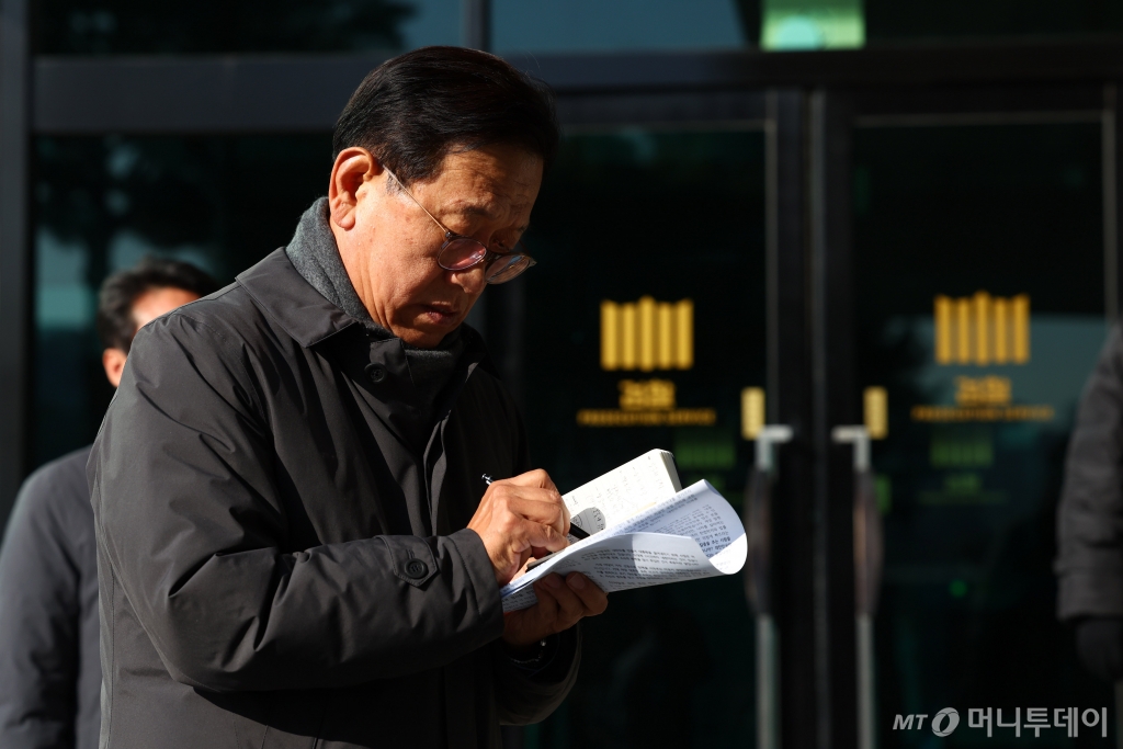 [서울=뉴시스] 전신 기자 = 윤석열 대통령 측 변호인단 구성에 관여하는 석동현 변호사가 19일 서울 서초구 서울고등검찰청 앞에서 기자회견 전 메모장을 살펴보고 있다. 2024.12.19. photo1006@newsis.com /사진=전신