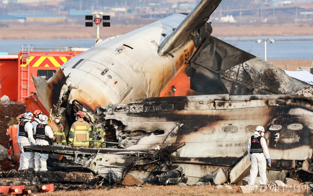 [무안=뉴시스] 이영환 기자 = 전남 무안국제공항에서 여객기 착륙 도중 충돌 사고가 난 29일 오후 무안국제공항에서 구급대원들이 기체 내부 탑승객 수색을 하기 위해 가림막을 설치하고 있다. 2024.12.29. 20hwan@newsis.com /사진=김근수