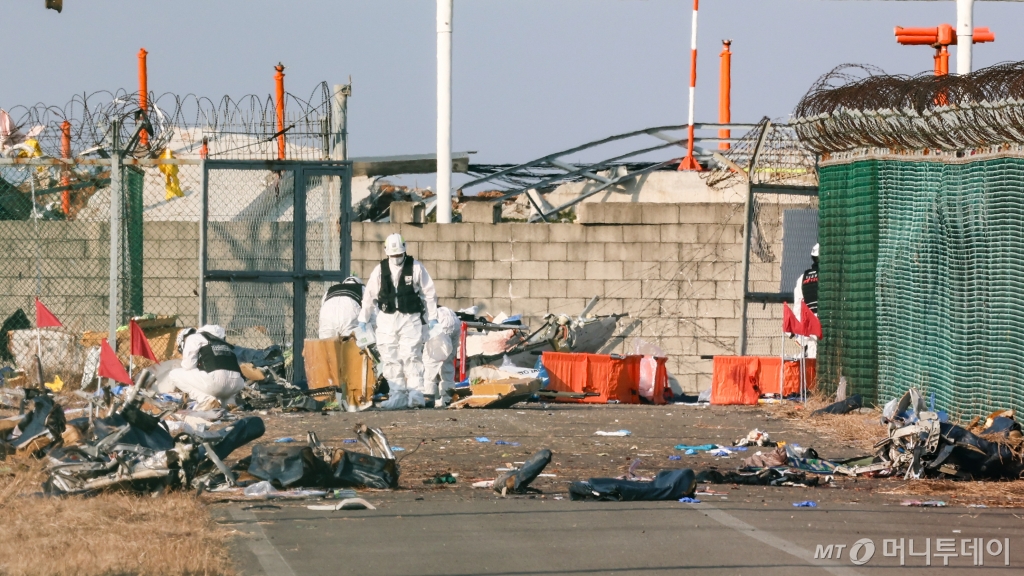 [무안=뉴시스] 이영환 기자 = 전남 무안국제공항에서 여객기 착륙 도중 충돌 사고가 난 29일 오후 무안국제공항에서 사고 조사 대원들이 사고현장을 수습하고 있다. 2024.12.29. 20hwan@newsis.com /사진=김근수