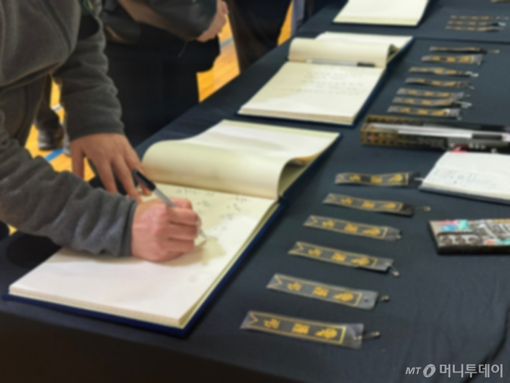 30일  전남 무안국제공항에서 일어난 제주공항 참사 희생자를 기리는 합동분향소가 30일 무안스포츠파크 실내체육관에 마련됐다. 방명록을 작성하는 조문객들./사진=김선아 기자