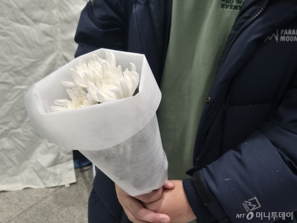 목포대에 재학 중인 김모씨(22)는 오후 1시30분쯤 국화꽃 세 송이를 들고 공항을 찾았다. 그는 "한 송이는 참사 희생자들을 위해, 한 송이는 유가족을 위해, 또 다른 한 송이는 무안군민을 포함한 대한민국 국민들께 바치는 마음으로 가져왔다"고 밝혔다. 당초 합동분향소는 31일 오후 2시쯤 열릴 예정이었지만 공간 조성을 위한 시간이 길어지며 오후 7시가 돼서야 운영을 시작했다./사진=박진호 기자