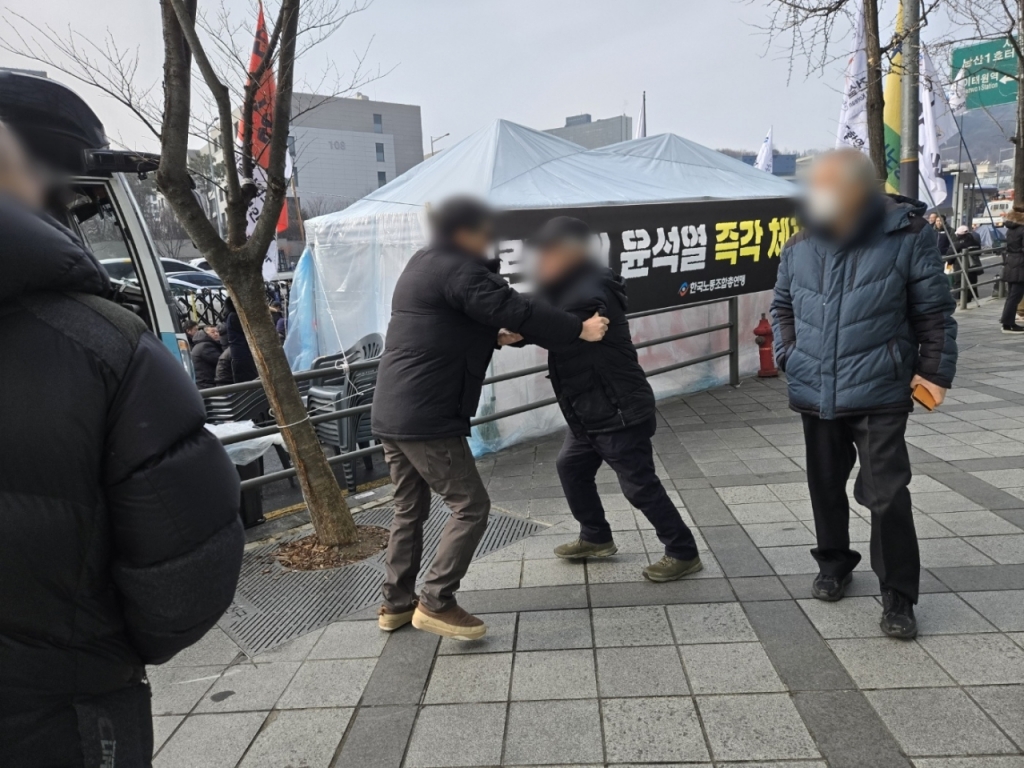 한남동 집회에 참가한 70대 남성이 시비를 걸자 집회 관계자가 말리는 모습. / 사진=이찬종 기자 