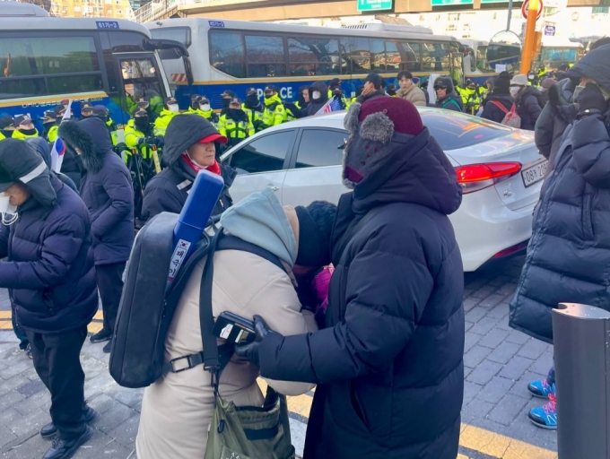 15일 오전 9시쯤 서울 용산구 한남동 관저 앞에서 한 남성이 눈물을 흘리자 중년 여성이 달래주는 모습. /사진=이현수 기자