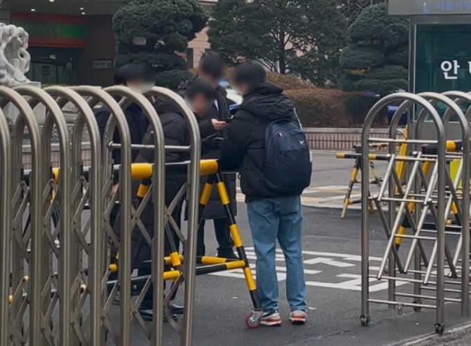 20일 오전 8시쯤 서울서부지법 정문 앞 법원 직원이 경찰에 신분증을 제시하고 출근하고 있다./사진=이현수 기자