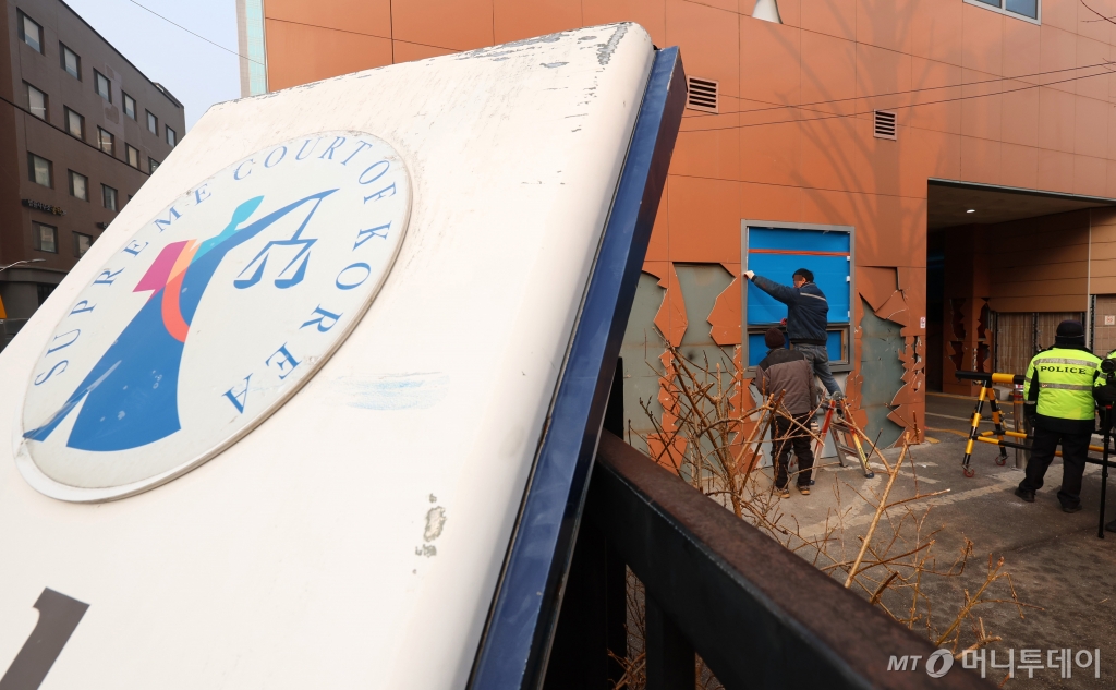 [서울=뉴시스] 이영환 기자 = 20일 오전 서울 마포구 서울서부지방법원에서 공사 관계자들이 파손된 외벽 및 창문 보수작업을 하고 있다.  지난 19일 새벽 윤석열 대통령의 구속영장 발부에 지지자들이 집단 폭력 및 법원 안으로 침입하는 사고가 발생했다. 한편 서울서부지방법원은 법원은 정상적으로 운영될 것이라고 밝혔다. 다만 차량을 통한 출입은 불가능하고 출입자는 신분 확인이 필요하다고 전했다.  2025.01.20. 20hwan@newsis.com /사진=이영환