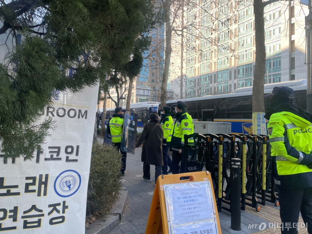24일 오전 통제 중인 서울서부지법 청사 앞을 한 여성이 지나치려하자, 경찰이 방패를 들고 함께 이동하고 있다. /사진= 이지현 기자.