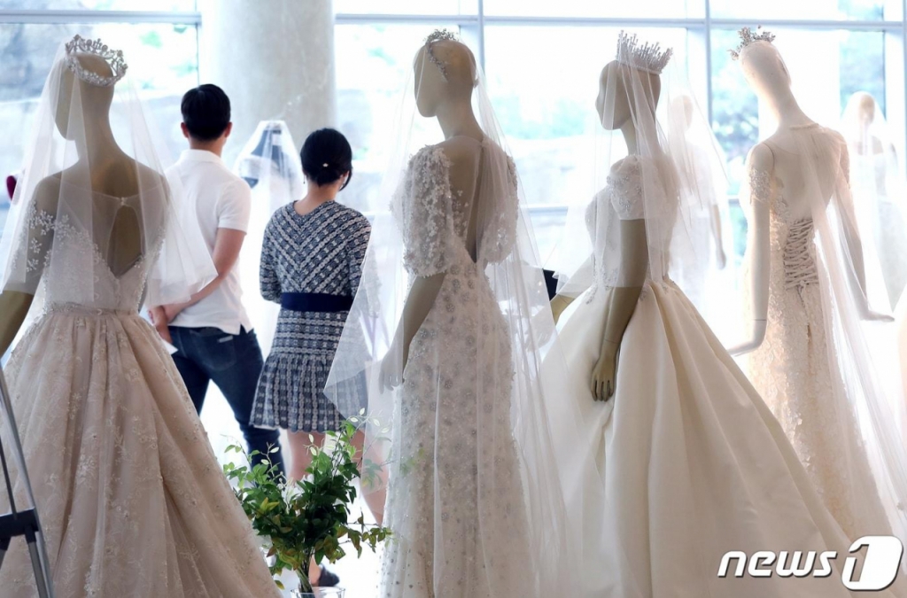 2019년 서울의 한 웨딩박람회를 찾은 예비 부부가 드레스 등 결혼 관련 상품을 둘러보고 있다. /사진=뉴스1.