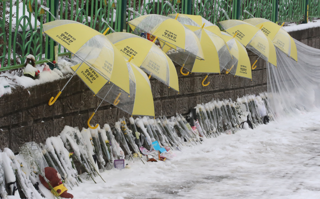 12일 대전 초등학생 피살사건이 발생한 대전 서구의 한 초등학교 정문에 추모객들이 놓고 간 국화과 편지 위에 우산이 설치돼 있다. /사진=뉴스1.