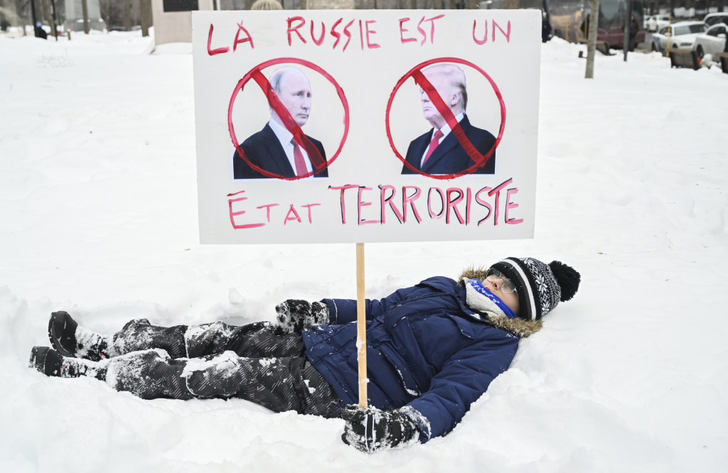 2월23일(현지 시간) 캐나다 몬트리올에서 러시아의 우크라이나 침공 3주년(2월 24일)을 맞아 이를 규탄하는 집회가 열려 한 어린이가 블라디미르 푸틴 러시아 대통령과 도널드 트럼프 미국 대통령을 테러리스트라고 표현한 팻말을 들고 있다. /AP=뉴시스