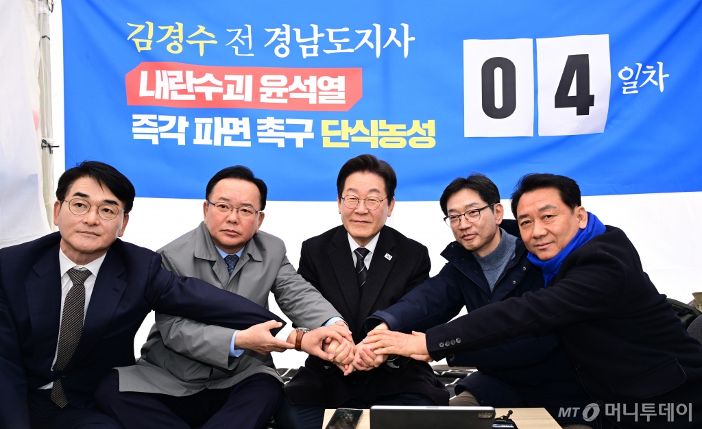 박용진 전 의원과 김부겸 전 국무총리, 이재명 더불어민주당 대표, 김경수 전 경남지사, 이광재 전 국회 사무총장(왼쪽부터)이 지난 12일 오후 서울 광화문 인근 천막에서 윤석열 대통령 파면을 촉구하며 단식 농성에 돌입한 김 전 지사를 응원하며 손을 모아 결의를 다지고 있다. / 사진제공=뉴스1