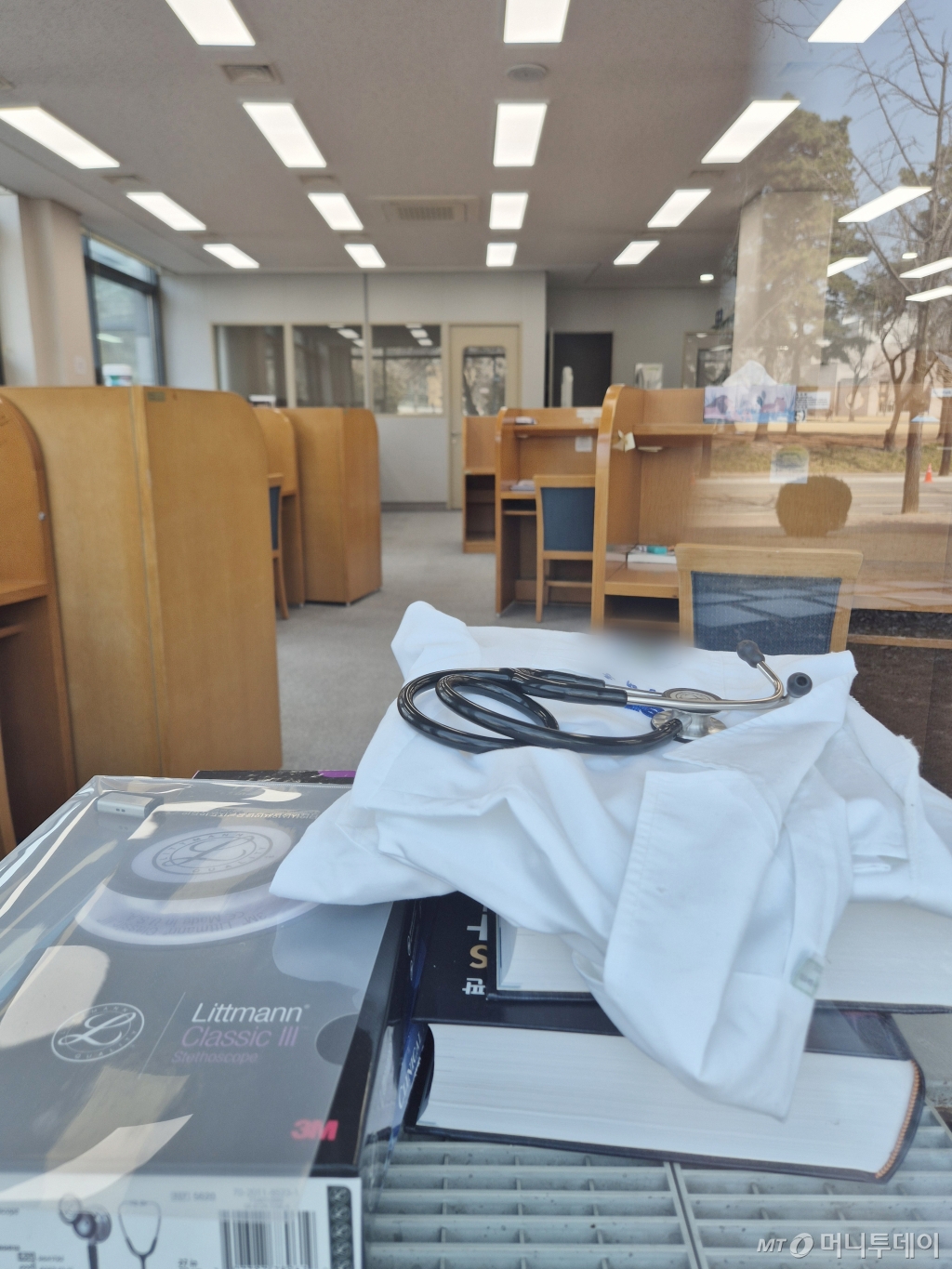 (경기=뉴스1) 김영운 기자 = 의과대학을 운영하는 40개 대학 총장들이 의대생들이 제출한 휴학계를 승인하지 않고 21일까지 반려 완료 처리하기로 결정했다. 아울러 총장들은 유급이나 제적 등 상황이 발생하면 원칙대로 처리하고 개별 대학 학칙을 의대에도 동일하게 엄격히 적용하기로 합의했다.  사진은 21일 경기도 내의 한 의과대학 도서관에 전공서적과 가운, 청진기가 놓여져 있는 모습. 2025.3.21/뉴스1  Copyright © 뉴스1. All rights reserved. 무단 전재 및 재배포,  AI학습 이용 금지. /사진=(경기=뉴스1) 김영운 기자