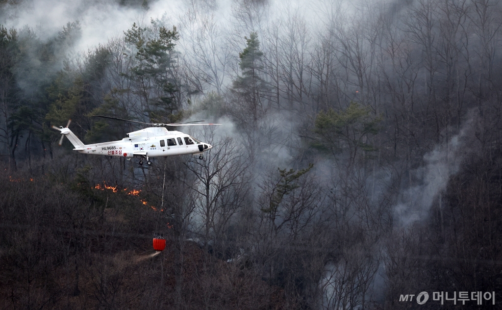 [의성=뉴시스] 이무열 기자 = 22일 경북 의성군 의성읍 원당리 마을 인근까지 산불이 번져 산불진화헬기가 산불 진화에 나서고 있다. 2025.03.22. lmy@newsis.com /사진=이무열