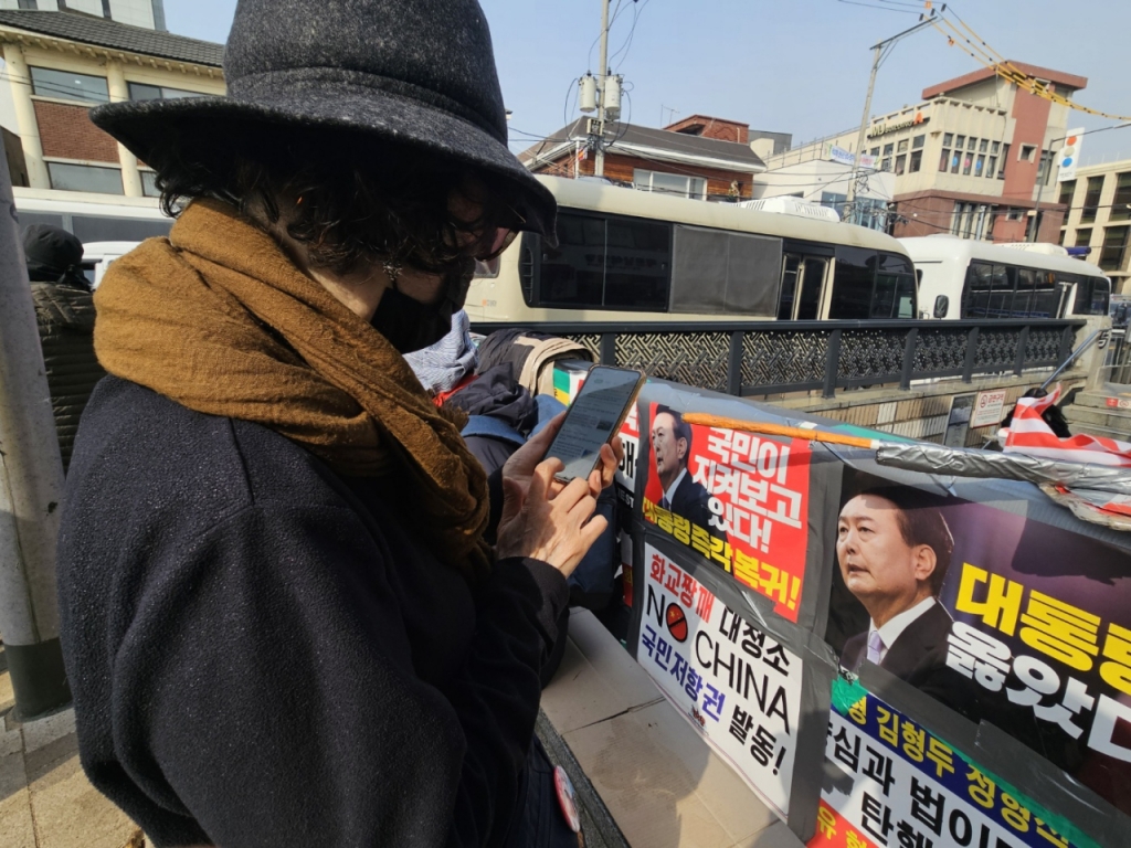 24일 오전안국역 2번출구 근처에 있던 60대 여성 김모씨가 휴대전화 검색창에 '한덕수 선고'를 검색한 뒤 수시로 새로 고침 버튼을 누르고 있다. /사진=박상혁 기자. 