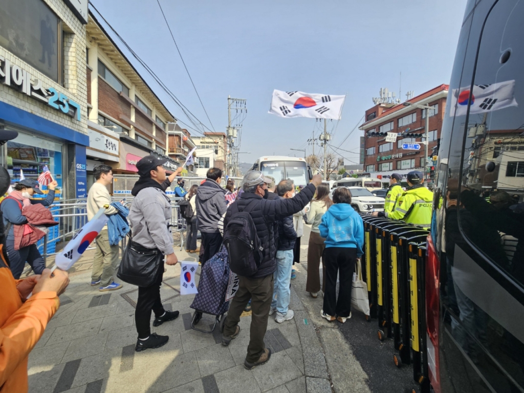 24일 오전 한덕수 탄핵 반대 집회 참가자들이 기각 선고 소식을 듣자 서울 종로구 헌법재판소 근처에서 태극기를 휘날리며 기뻐하고 있다. /사진=박상혁 기자.